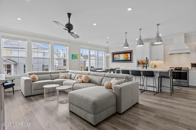 a living room with furniture kitchen view and a flat screen tv