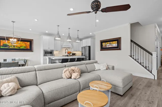 a kitchen with stainless steel appliances a dining table chairs refrigerator and microwave