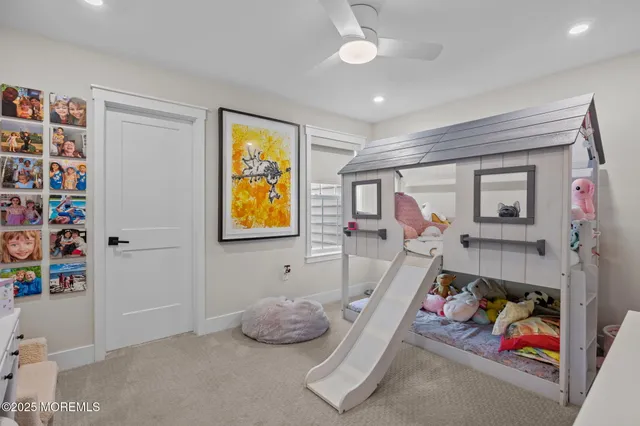 a living room with furniture and a bookshelf with wooden floor