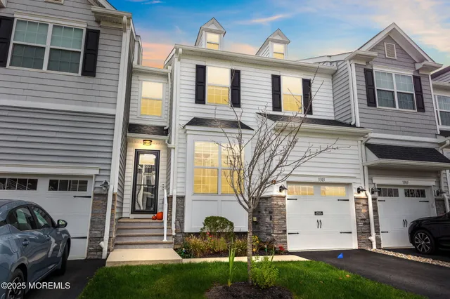 a view of a white house with large windows and a yard