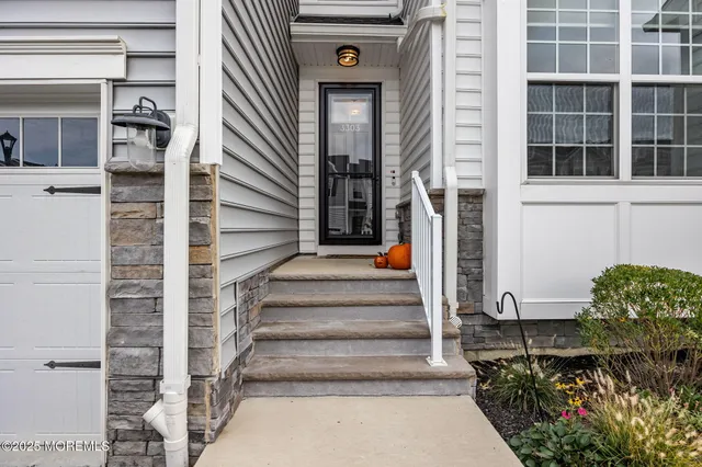 a hallway with a white cabinets and wooden floor