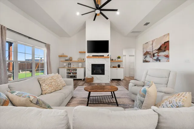 a living room with furniture a flat screen tv and a fireplace