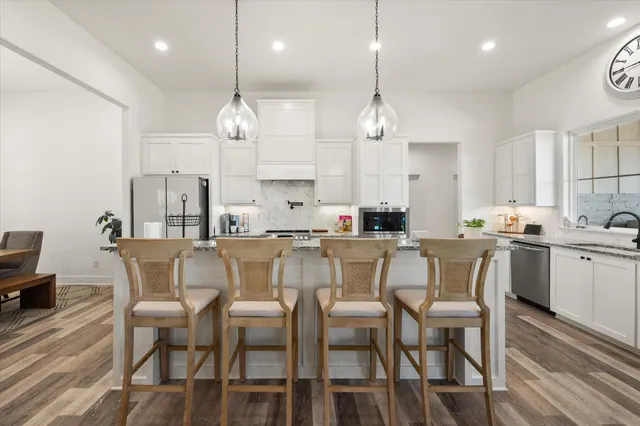 a dining room filled chandelier and kitchen view