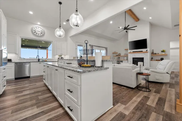 a large white kitchen with a large island oven a stove and a couch