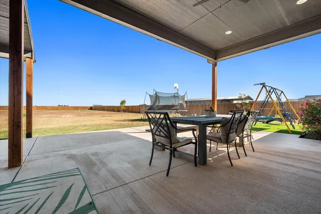 a view of an outdoor dining space with furniture and umbrella