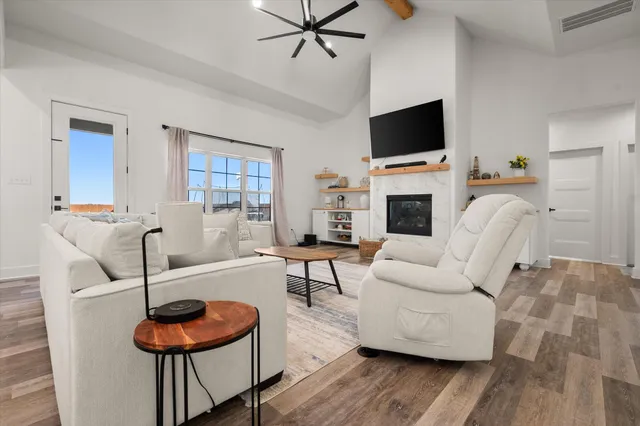a living room with furniture a fireplace and a flat screen tv