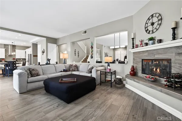 a living room with furniture kitchen view and a flat screen tv