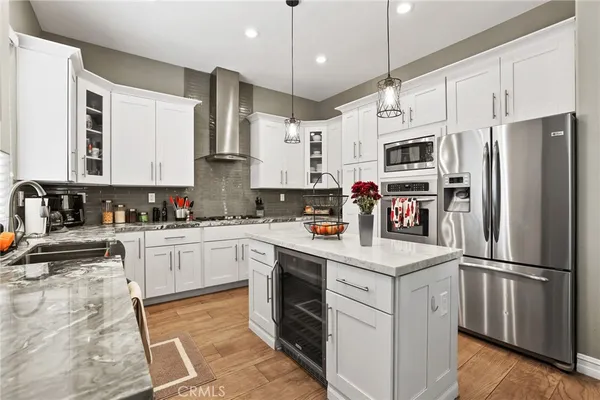 a kitchen with granite countertop white cabinets sink and stainless steel appliances