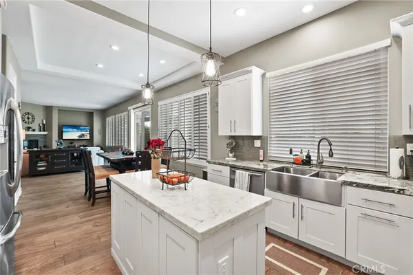 a kitchen with stainless steel appliances granite countertop a refrigerator a stove a sink dishwasher and a refrigerator with wooden floor