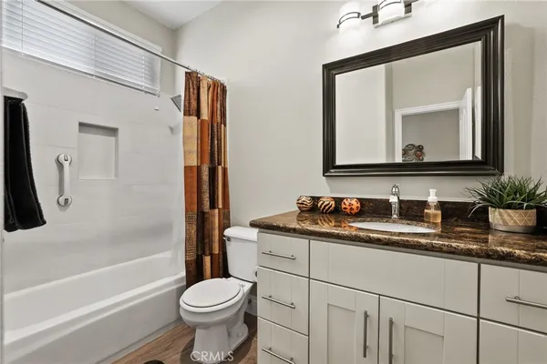 a bathroom with a granite countertop toilet sink and mirror