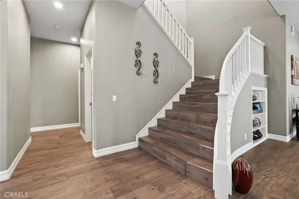 a view of staircase with white walls and a painting on the wall