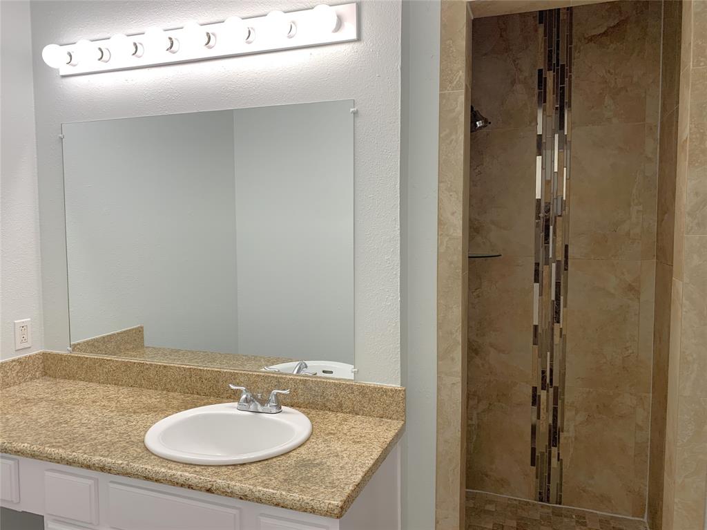9601 Forest Lane, Unit 1024 Dallas, TX 75243 - Photo 19 of 28 a bathroom with a granite countertop sink and a mirror