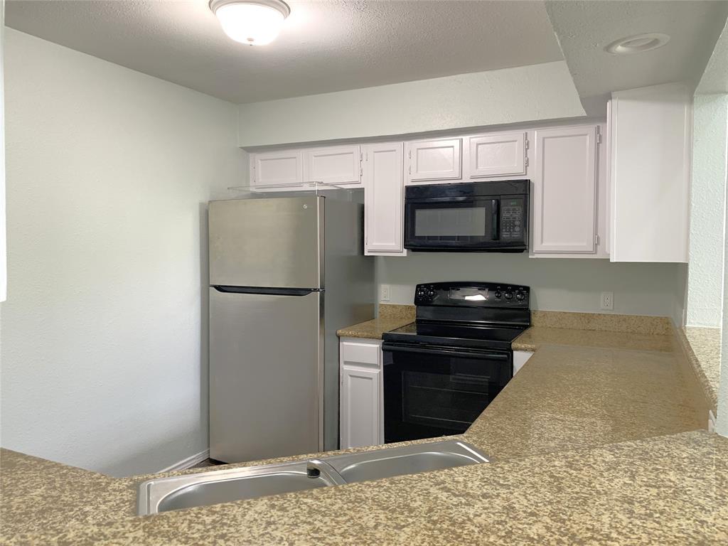 9601 Forest Lane, Unit 1024 Dallas, TX 75243 - Photo 10 of 28 a kitchen with a refrigerator and a stove top oven