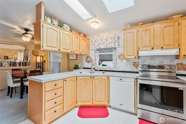 a kitchen with cabinets appliances and a window