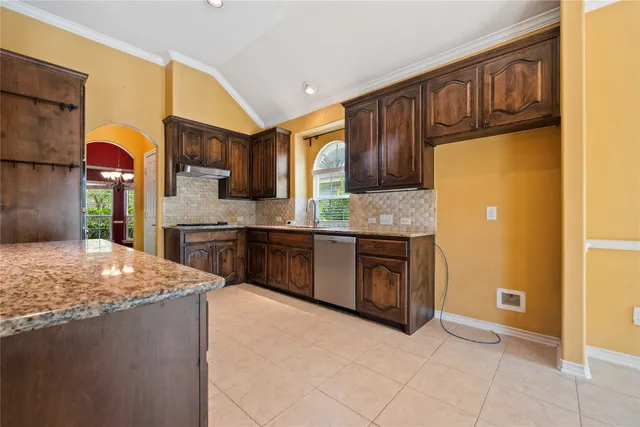 a kitchen with stainless steel appliances granite countertop a refrigerator and a stove top oven