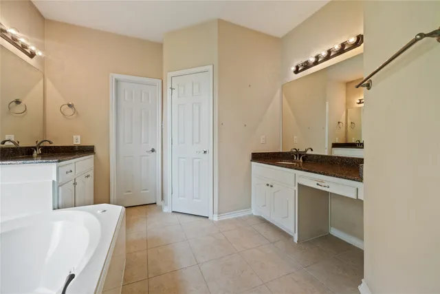 a spacious bathroom with a granite countertop sink and a mirror