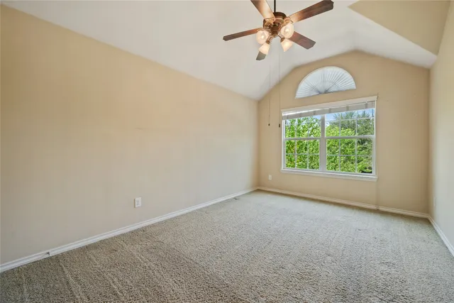 an empty room with a window and a fan
