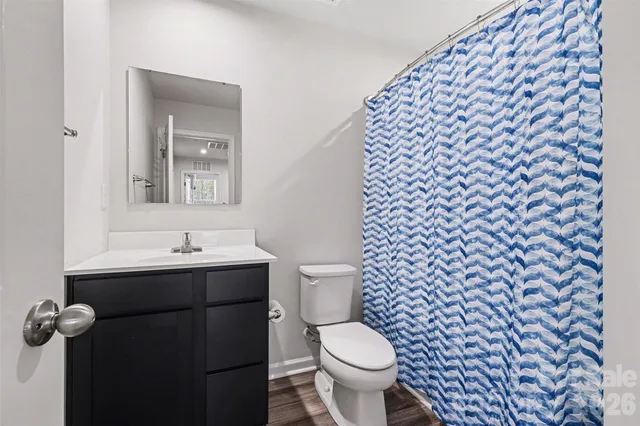 a bathroom with a toilet and a shower curtain