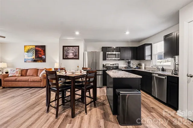 a view of kitchen with kitchen island stainless steel appliances microwave stove dining table and chairs