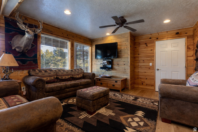 1505 West Elk Ridge Drive Alton, UT 84710 - Photo 11 of 53 Living room with recessed lighting, wood walls, hardwood / wood-style flooring, a ceiling fan, and a textured ceiling