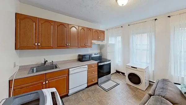 a view of a kitchen with cabinets dryer and washer