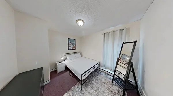 a living room with a rug and a wooden floor