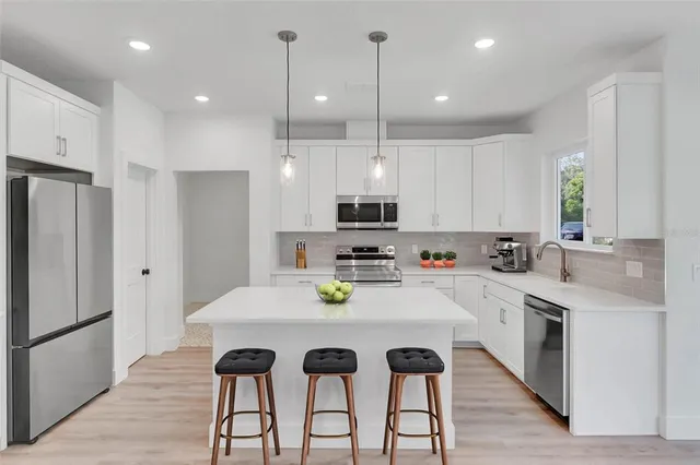 a view of kitchen with refrigerator and wooden floor