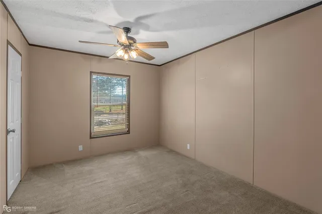 an empty room with windows and fan