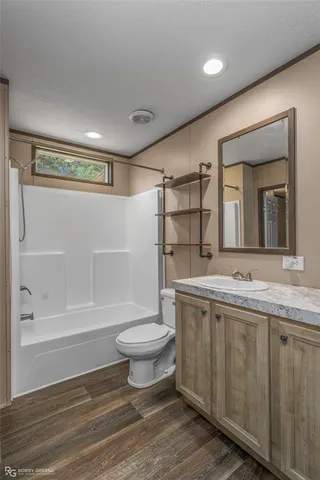 a bathroom with a granite countertop sink toilet a mirror and shower