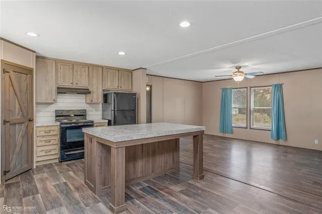 a kitchen with kitchen island a stove a sink and a refrigerator