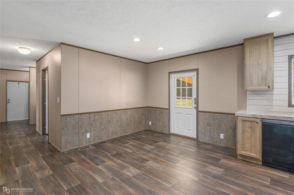 295 Cass Pvt Drive Gloster, LA 71030 - Photo 10 of 28 a view of an empty room with wooden floor and a kitchen