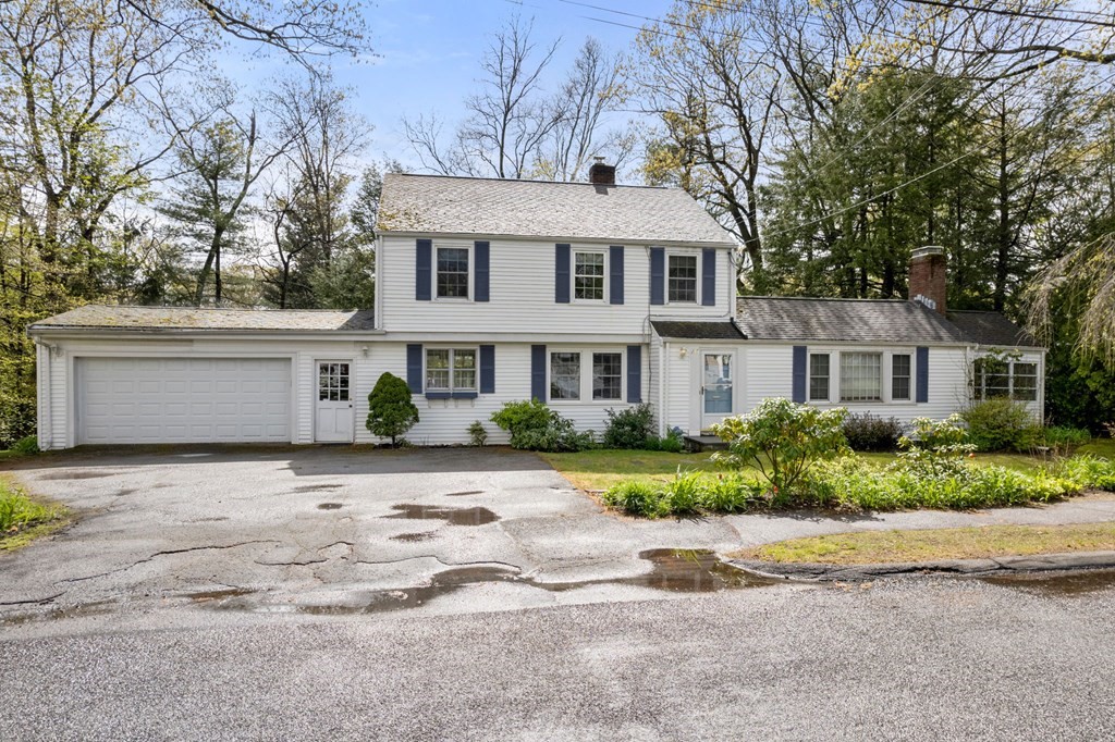 a front view of a house with a yard and potted plants
