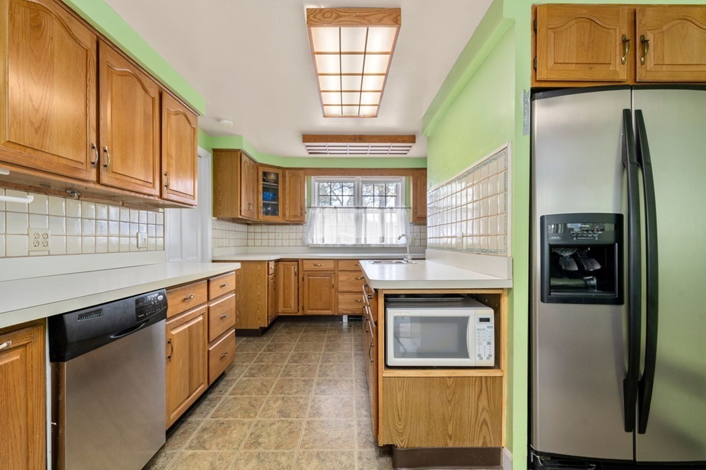 135 Tower Avenue Needham, MA 02494 - Photo 14 of 24 a kitchen with stainless steel appliances granite countertop a refrigerator a sink and a stove