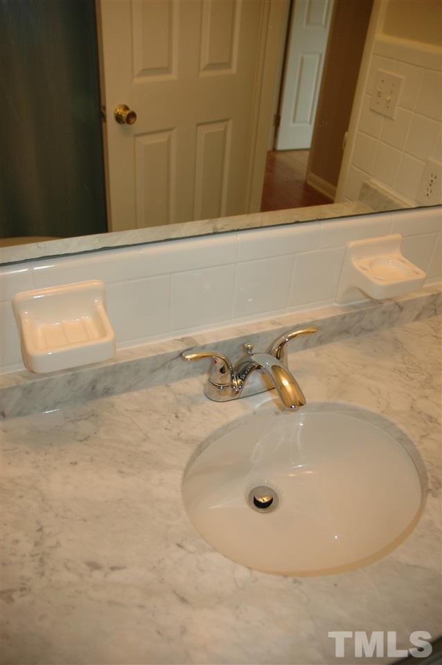716 Currituck Drive Raleigh, NC 27609 - Photo 15 of 19 Remodeled bath with Tub/Shower combo, white cabinets, marble counters, & new chrome faucet and sink.