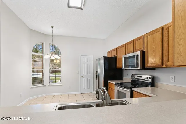 a kitchen with a window a sink and a microwave