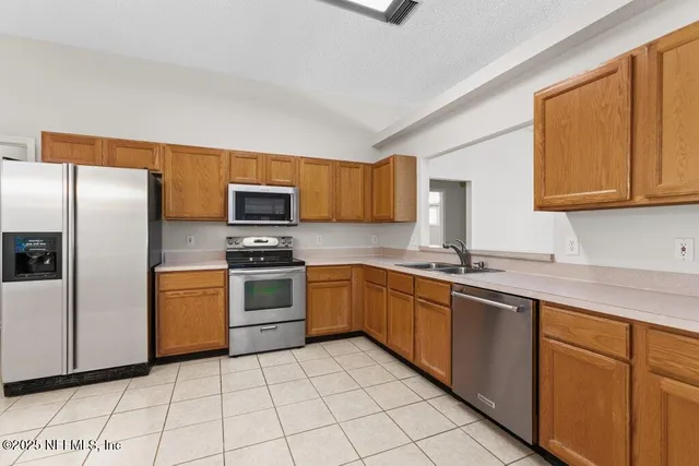 a kitchen with stainless steel appliances granite countertop a stove a sink dishwasher and a refrigerator