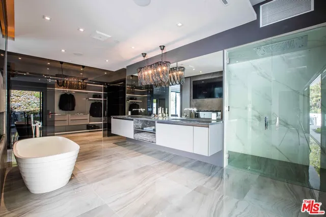 a large room with kitchen island a large counter top space a sink stainless steel appliances and cabinets