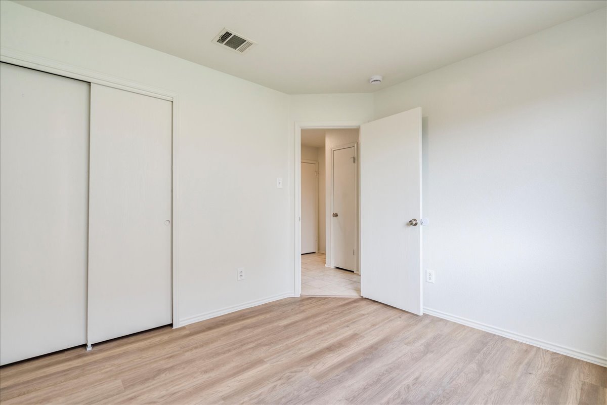 100 Easy Street Hutto, TX 78634 - Photo 21 of 36 An inviting room features light wood flooring and a spacious sliding door closet.