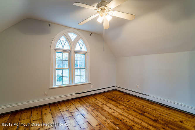 801 Adelphia Road Freehold, NJ 07728 - Photo 38 of 43 an empty room with wooden floor fan and windows
