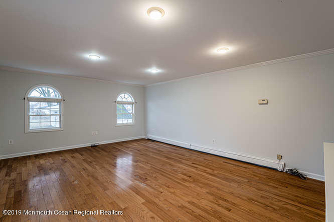 801 Adelphia Road Freehold, NJ 07728 - Photo 41 of 43 an empty room with wooden floor and windows