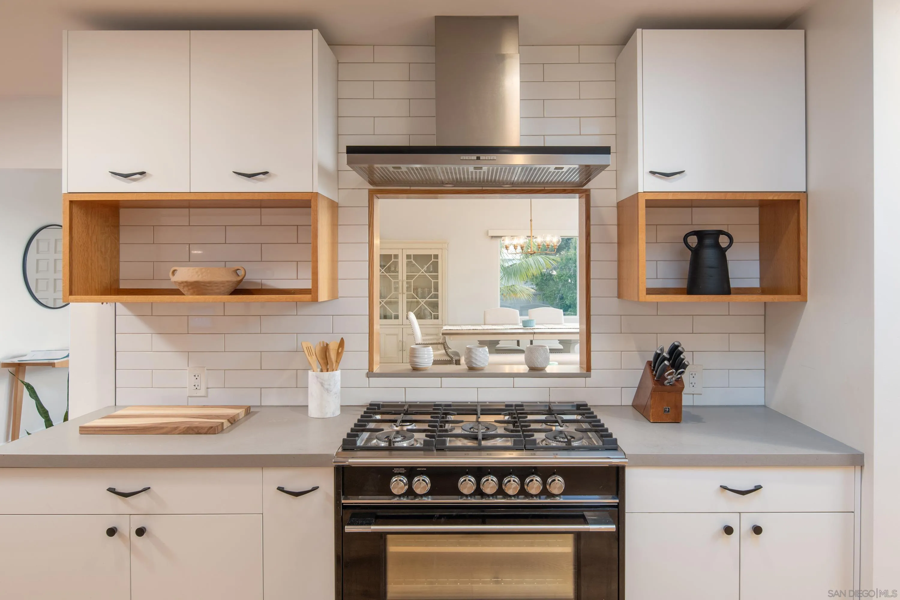 6529 Manana Place La Jolla, CA 92037 - Photo 13 of 36 a kitchen with stainless steel appliances a stove a white cabinet and a granite counter tops
