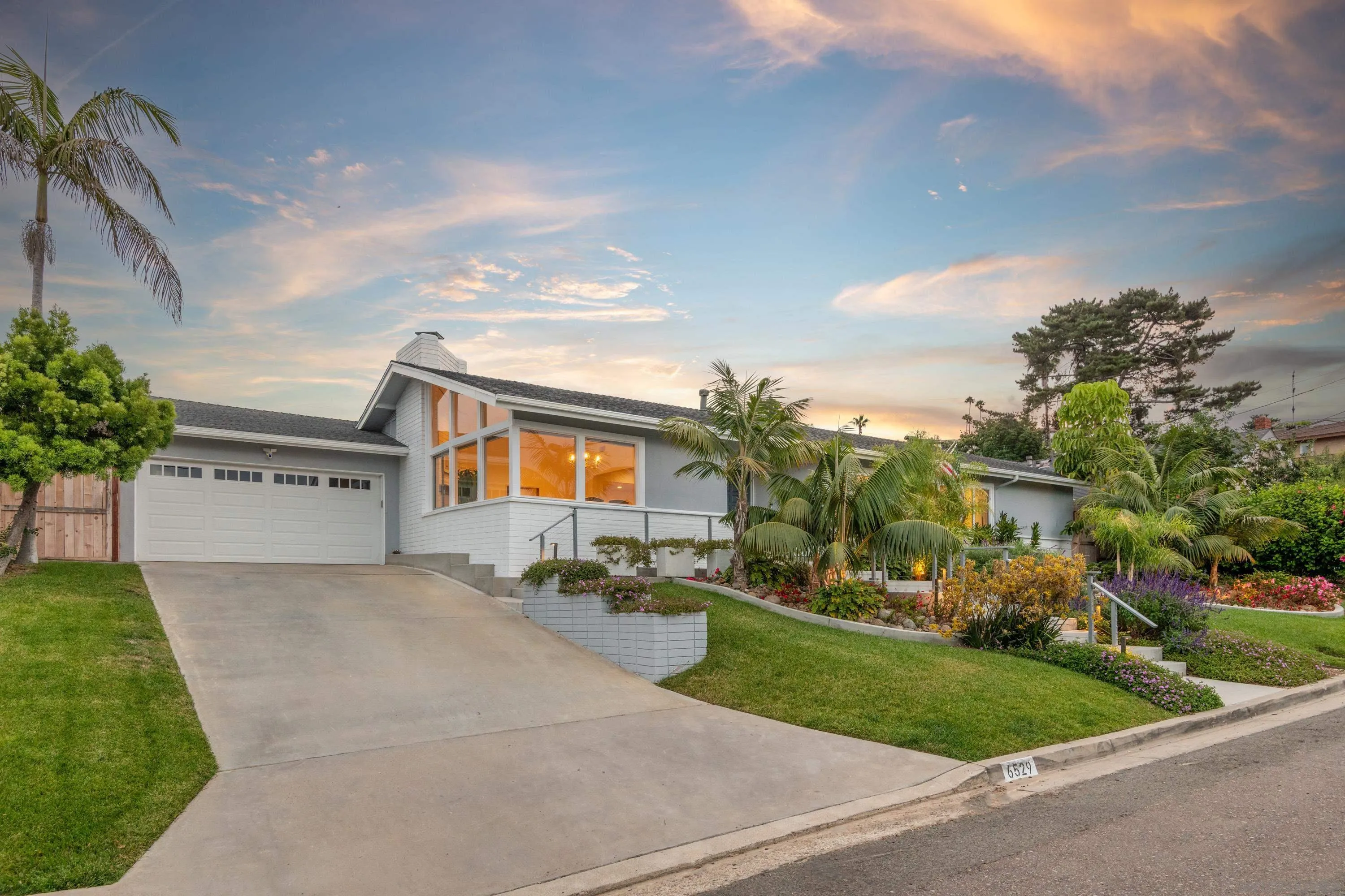 6529 Manana Place La Jolla, CA 92037 - Photo 2 of 36 a front view of a house with a yard and trees