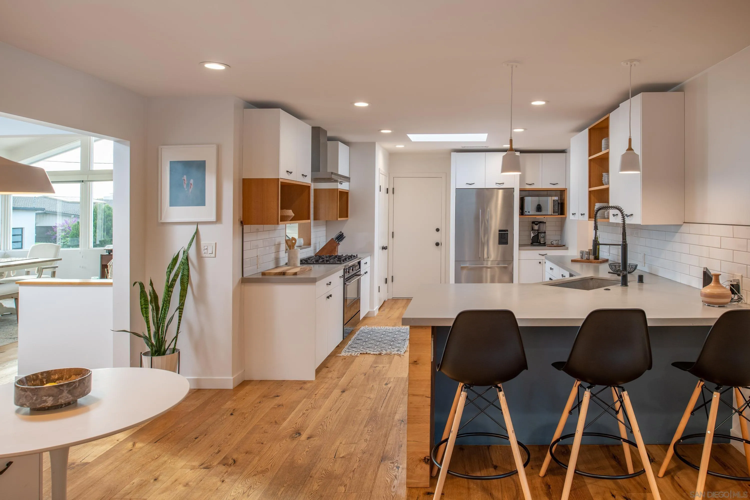 6529 Manana Place La Jolla, CA 92037 - Photo 8 of 36 a kitchen with stainless steel appliances kitchen island granite countertop a kitchen island and chairs in it