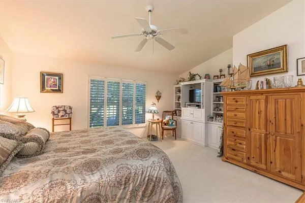 a spacious bedroom with a bed a dresser and a large window