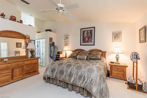 a spacious bedroom with a bed and a chandelier