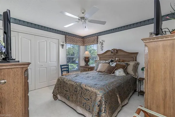 a bedroom with a bed and a ceiling fan