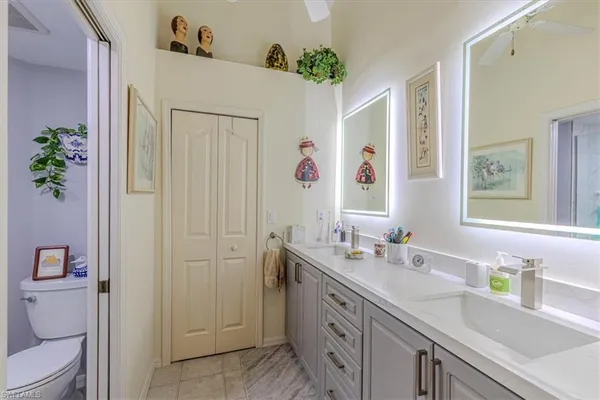 a bathroom with a granite countertop sink a toilet and a mirror