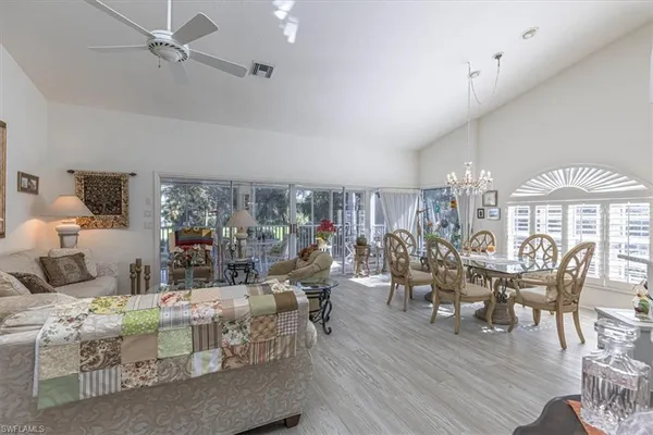 a living room with furniture a chandelier and a dining table