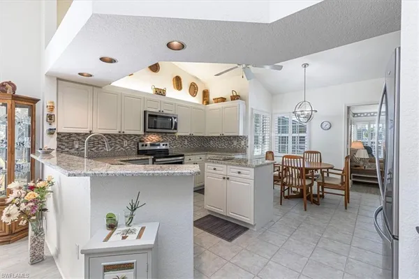 a kitchen with cabinets and chairs