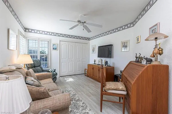 a living room with furniture a ceiling fan and a rug